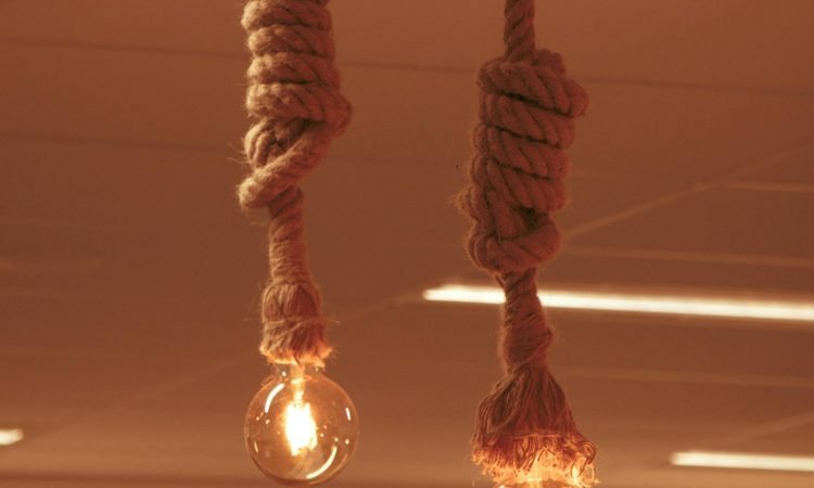 Two lightbulbs suspended from the ceiling using rope