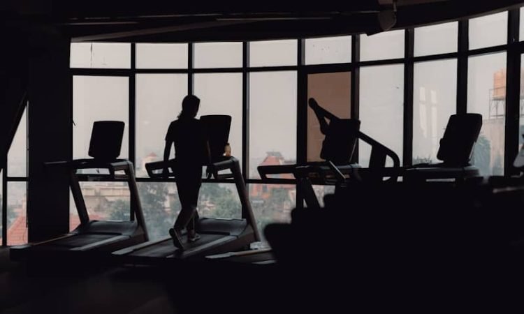 A silhouette of a person on a treadmill