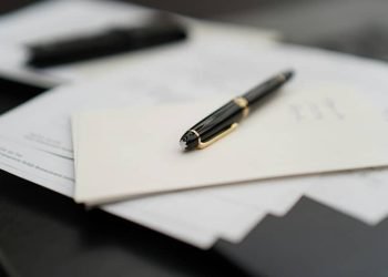 A pen sitting on top of a pile of papers